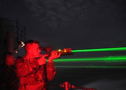 FIGURE 1. Troops test-fire optical distractors on the aircraft carrier USS Abraham Lincoln. Note how the beams spread rapidly, reducing the nominal ocular hazard distance and spreading the beam over a wider area on targets.