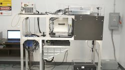 FIGURE 2. In the test stand, the POLYtek high-speed polygon scan head is placed in the middle section of the test frame with the laser on the top. An f-theta lens is facing downward toward the test bed table, which is located directly below it. The target is lying on the test bed below. The controller software is running on notebook computer. FIGURE 2. In the test stand, the POLYtek high-speed polygon scan head is placed in the middle section of the test frame with the laser on the top. An f-theta lens is facing downward toward the test bed table, which is located directly below it. The target is lying on the test bed below. The controller software is running on notebook computer.