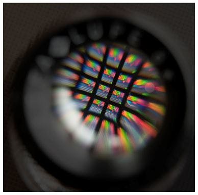 FIGURE 1. An 8 &times; 8 array bandpass filter is viewed through a magnifier.