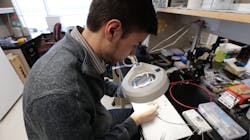 Baris Ozbay examines the tiny laser-scanning microscope. Baris Ozbay examines the tiny laser-scanning microscope.