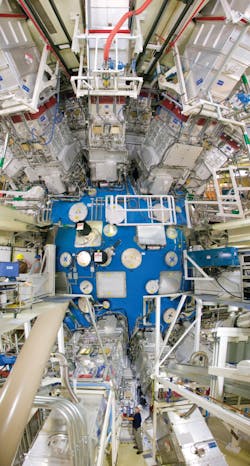 FIGURE 1. The Lawrence Livermore National Laboratory (LLNL) National Ignition Facility (NIF) target chamber; for scale, note worker in yellow helmet at left middle of photo. FIGURE 1. The Lawrence Livermore National Laboratory (LLNL) National Ignition Facility (NIF) target chamber; for scale, note worker in yellow helmet at left middle of photo.