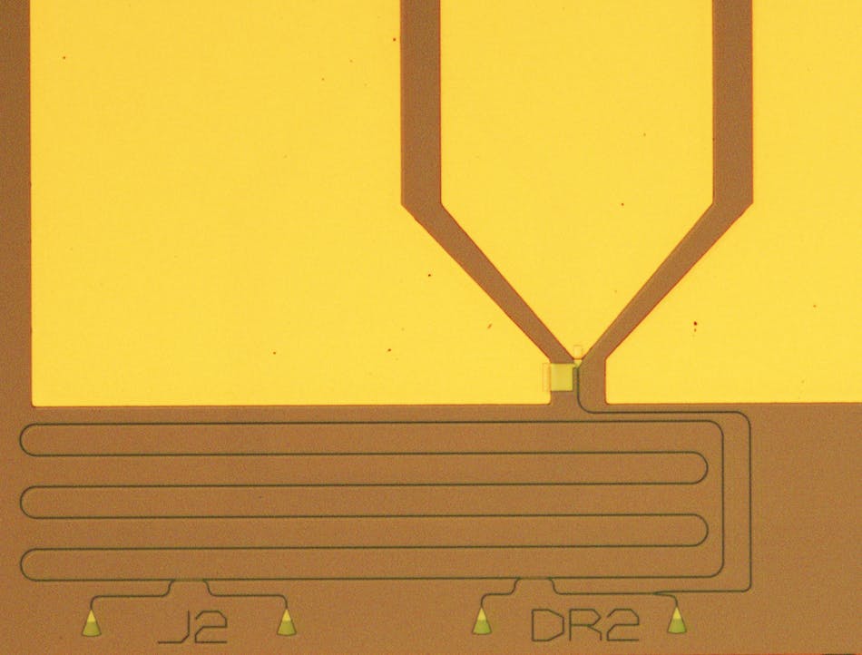 FIGURE 2. A microscope image shows a nanophotonic integrated circuit equipped with a superconducting nanowire single-photon detector. The circuit features four optical input ports as well as an on-chip microring resonator for time-resolved measurements. The detector device is located between the metal contact pads in the upper half of the image.