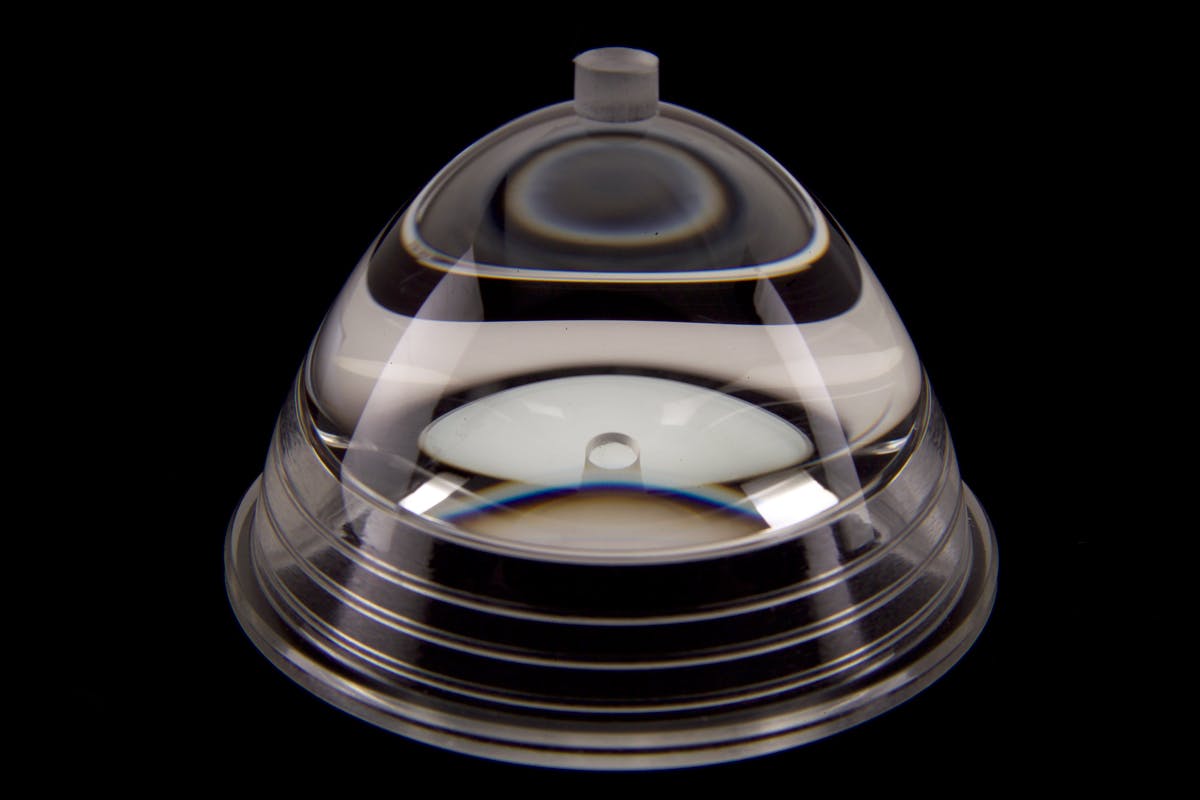 FIGURE 2. Complex optical designs previously limited to glass optics are now possible in plastic, including this lens which has multiple optical surfaces with various mounting features.