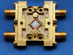 A superconducting array of microwave kinetic inductance detectors (MKIDs) is mounted in a gold-plated copper box (shown); a square array of circular microlenses (at center) focuses incoming light onto the individual detectors. The entire structure is cooled in a dilution refrigerator to about 100 mK.