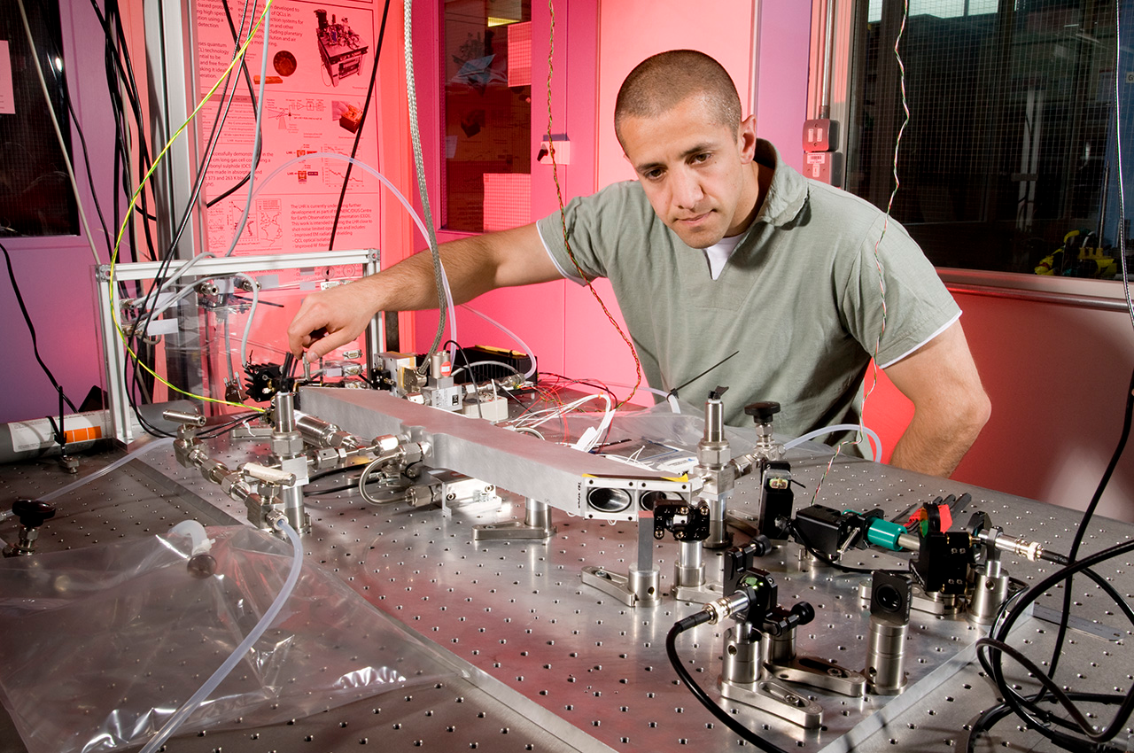 Researcher Ali Hussain adjusts a dual-laser setup that measures isotope ratios. Designed for use on Mars, the system is being adapted to measure samples of common foods to pinpoint their geographic origin.