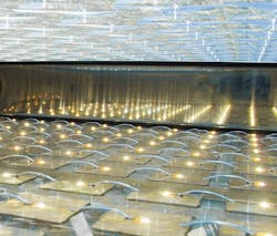 FIGURE 3. Looking inside the 80 × 40 cm CPV module from Concentrix shows 200 Fresnel lenses focusing solar irradiation onto 200 tiny, commercially available triple-junction solar cells. Concentrix says the Fresnel-only design reduces heat load on the cells, while top and bottom glass plates increase module reliability and robustness. FIGURE 3. Looking inside the 80 × 40 cm CPV module from Concentrix shows 200 Fresnel lenses focusing solar irradiation onto 200 tiny, commercially available triple-junction solar cells. Concentrix says the Fresnel-only design reduces heat load on the cells, while top and bottom glass plates increase module reliability and robustness.
