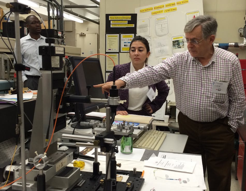 As graduate student Sabrina Grech (center) describes work in laser tissue welding, Senior Associate Researcher Stephane Lubicz, MD (right), describes the operation of instrumentation used for the work. Yisa Rumala, Ph.D. (left), who is part of the supercontinuum team at CCNY, served as a tour guide during the event.