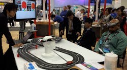 FIGURE 1. At SPIE Photonics West 2015, Hamamatsu&apos;s booth featured a double-track toy car racing game setup that involved two &apos;racer&apos; participants, who would each wear an electronic headband incorporating a NIRS optical probe able to wirelessly send signals to one of the cars on the track.