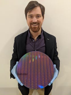 Dr. Chad Husko, CEO and founder of Iris Light, holds a 300 mm silicon wafer.