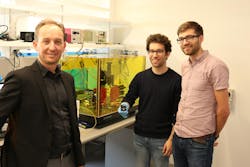 Alberto Peruzzo (left), Jean-Luc Tambasco, and Robert Chapman congregate around their quantum topological equipment.