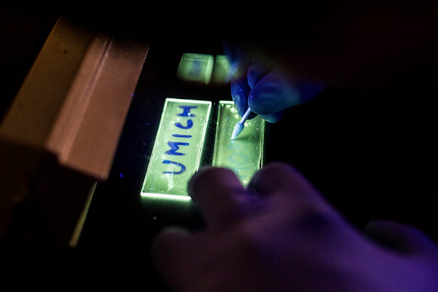 A phosphorescent OLED reveals the presence of water under backlight. Water causes polymers to break in the OLED, changing the light emission from phosphorescent light (green) to fluorescent light (blue).