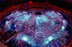 FIGURE 1. Huge electrical currents generate arcs and sparks on the Z machine at Sandia National Labs. The bright objects in the foreground are the laser triggered gas switches.