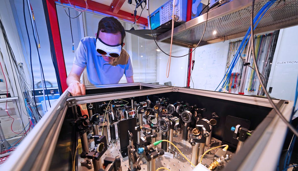 FIGURE 4. Maximilian L&ouml;w, a Ph.D. candidate in Professor Gerhard Rempe&rsquo;s Quantum Dynamics group at MPQ, distributes the frequency comb light needed to stabilize all lasers in the group&rsquo;s various laboratories.