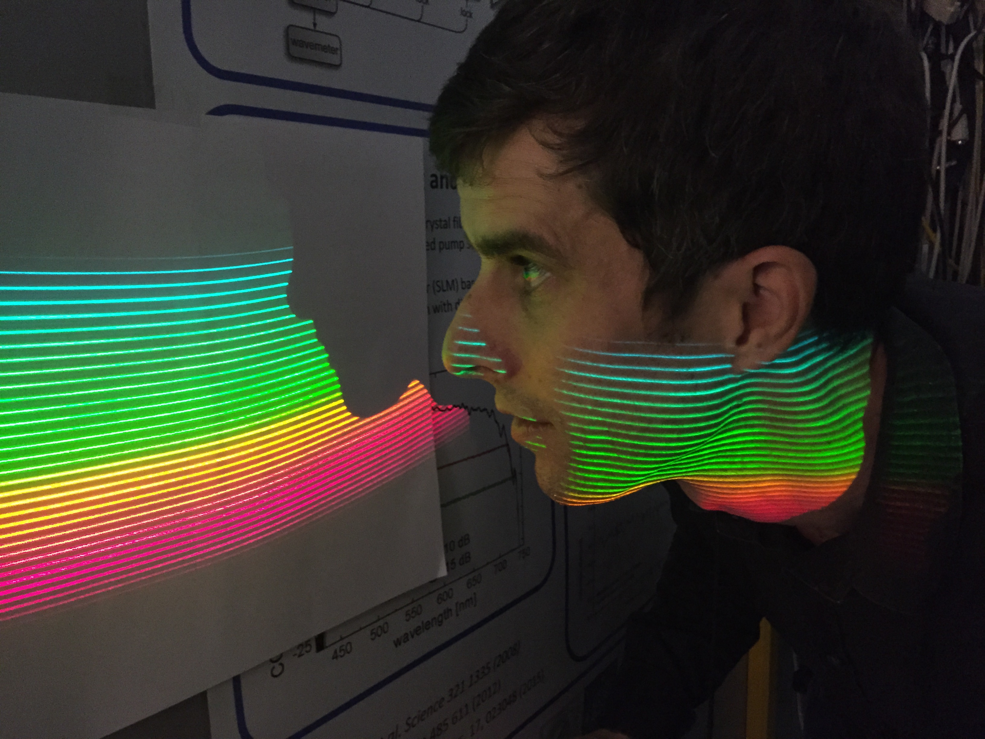 Tilo Steinmetz, Menlo's AstroComb product manager, inspects comb modes of the ESPRESSO-AstroComb projected onto a screen by means of an echelle spectrograph.