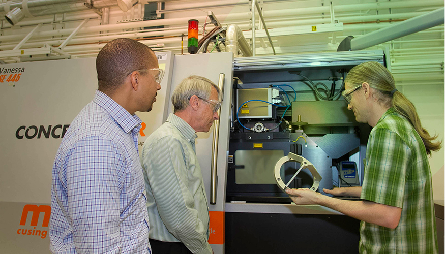 From left: LLNL researchers Ibo Matthews, a principal investigator leading the Lab&rsquo;s effort on the joint open source software project; Wayne King, director of the Accelerated Certification of Additively Manufactured Metals Initiative; and Gabe Guss, engineering associate examine a 3D-printed part manufactured using the selective laser melting process.