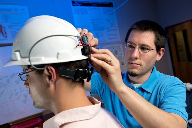 Jason B. Forsyth places a wearable pulse oximetry computing system on a helmet to protect construction workers from carbon monoxide poisoning. The work garnered the Virginia Tech researchers a Best Paper award.