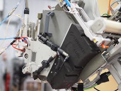 FIGURE 2. A Coriolis C-solo robot arm with the Cailabs fiber placement head (shown at left). FIGURE 2. A Coriolis C-solo robot arm with the Cailabs fiber placement head (shown at left).