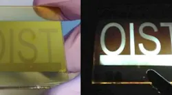 A large perovskite-based LED produced using chemical vapor deposition is connected to a 5 V current, illuminating an OIST pattern etched on the surface.