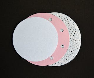 FIGURE 2. Three abrasive discs illustrate the progression from no holes, to 10mm-diameter holes, to high-density, 1.5mm-diameter micro-holes for dust extraction.