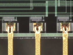 FIGURE 2. 0.015-in.-thick gold-coated copper flat wire welded to metallized pads. FIGURE 2. 0.015-in.-thick gold-coated copper flat wire welded to metallized pads.