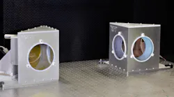 Closeup of two NIST radiation pressure power meters (RPPMs). Inside each metal housing is a mirror connected to a vertical balance. From this angle, the mirrors appear slightly yellow (left) and pink (right).