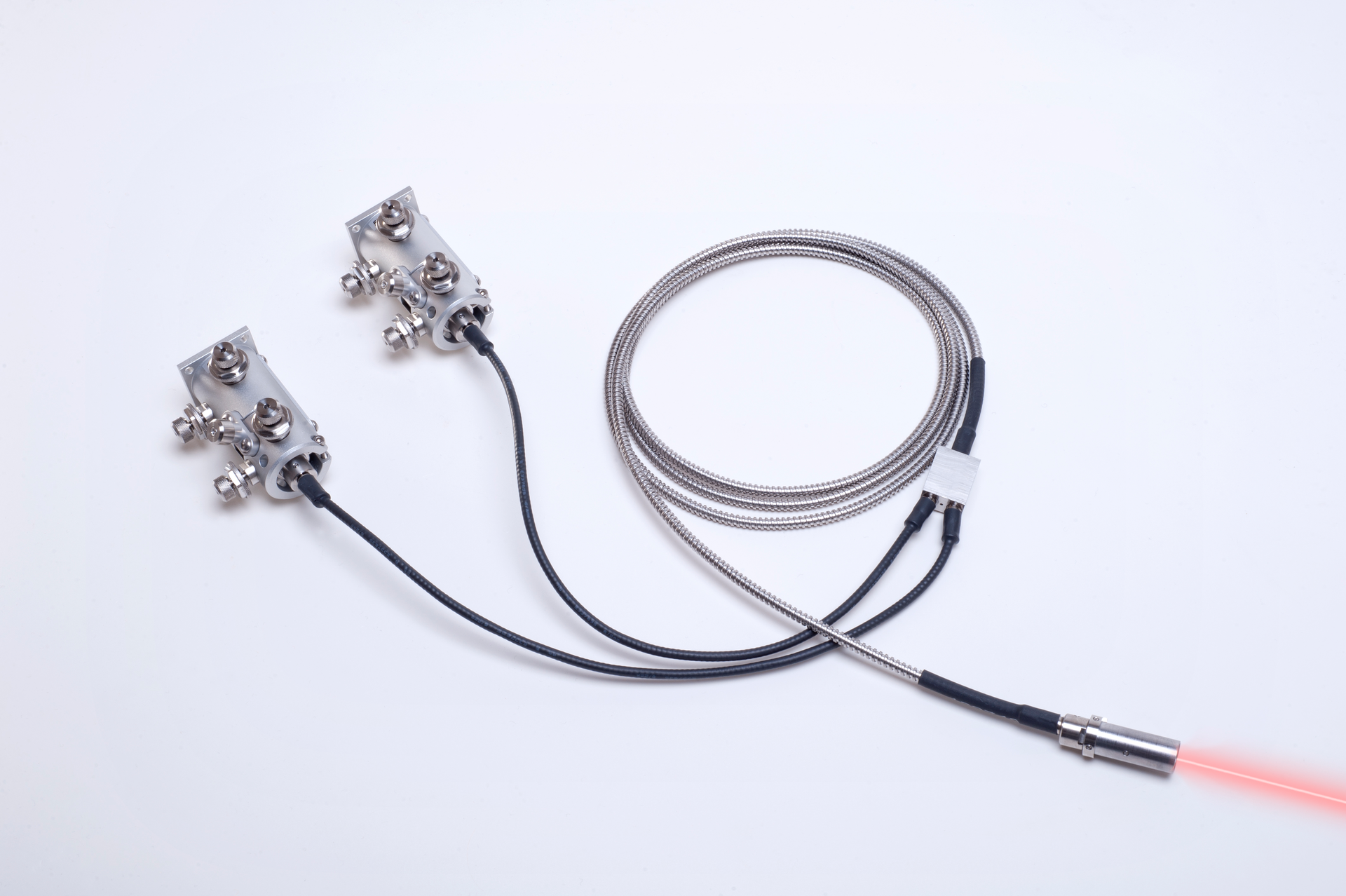 FIGURE 2. The two-line kineFLEX-Hydra fiber delivery system includes the integrated output beam-shaping optics that shape parallel and collinear beams. The system includes two kineMATIX manipulators, one at each input end for aligning and attaching the fibers to the individual lasers. By choosing to decouple the laser from the fiber at the laser side, the fiber can remain in situ and the output end can remain buried within the instrument when the laser is replaced at end of life. This then allows the laser to be located in a more convenient location for servicing and heat dissipation.