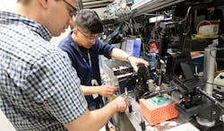 MITRE Quantum Moonshot team members Matthew Zimmermann (left) and Mark Dong working in the Quantum Moonshot Lab, Bedford, MA. MITRE Quantum Moonshot team members Matthew Zimmermann (left) and Mark Dong working in the Quantum Moonshot Lab, Bedford, MA.
