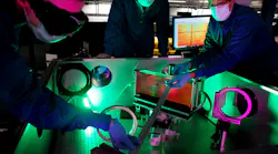 (L-R) Laser engineer Lauren Weinberg, research scientist John Nees, and research engineer Galina Kalinchenko pose for photos while working on the ZEUS laser at the NSF ZEUS laser facility in a Michigan Engineering lab.