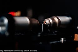 FIGURE 2. Close-up shot of the Bell state source. Light is coupled to and from the waveguide using aspheric lenses, and the waveguide is realized in an 8-mm-long periodically poled potassium titanyl phosphate (KTP) sample. FIGURE 2. Close-up shot of the Bell state source. Light is coupled to and from the waveguide using aspheric lenses, and the waveguide is realized in an 8-mm-long periodically poled potassium titanyl phosphate (KTP) sample.