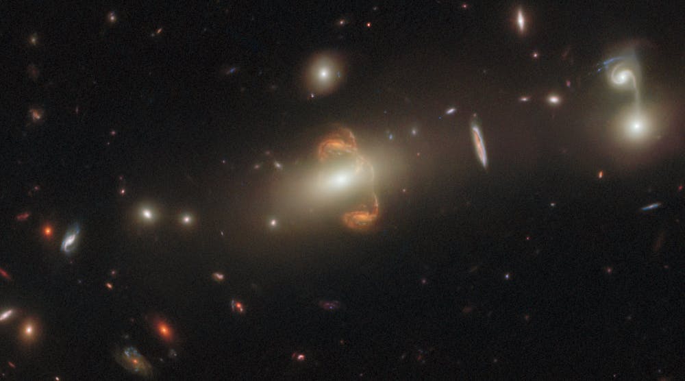 A gravitationally lensed galaxy, captured by the Hubble Space Telescope. A mirror image of the galaxy is at the center.