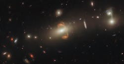 A gravitationally lensed galaxy, captured by the Hubble Space Telescope. A mirror image of the galaxy is at the center. A gravitationally lensed galaxy, captured by the Hubble Space Telescope. A mirror image of the galaxy is at the center.