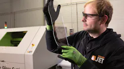 Inspecting a piece of thin glass cut with a laser.