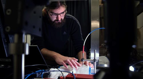 FIGURE 1. Brian Iezzi scans and measures the photonic fibers in the fabric he developed.