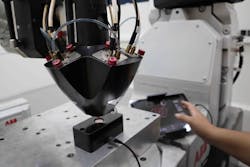 A deposition head during the alignment process in a robotic integration; the alignment camera is located at the working distance of the system. A deposition head during the alignment process in a robotic integration; the alignment camera is located at the working distance of the system.
