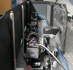 FIGURE 3. Signal arm of the QGI setup. In front, the photon pair source and dichroic mirror used to split signal and idler photons are shown. The SPAD imager is behind it.
