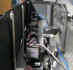FIGURE 3. Signal arm of the QGI setup. In front, the photon pair source and dichroic mirror used to split signal and idler photons are shown. The SPAD imager is behind it. FIGURE 3. Signal arm of the QGI setup. In front, the photon pair source and dichroic mirror used to split signal and idler photons are shown. The SPAD imager is behind it.