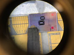 An active chip from one of the AIM Photonics PIC Kits being electrically and optically characterized at the University of Massachusetts Dartmouth (as seen under a microscope).
