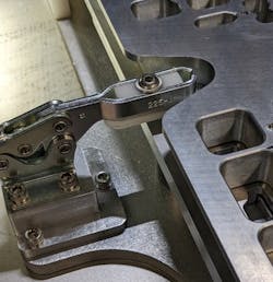 FIGURE 3. A typical lever clamp to fix the pallet fixture in place, where the pallet fixture was pre-loaded with components and assembled externally.