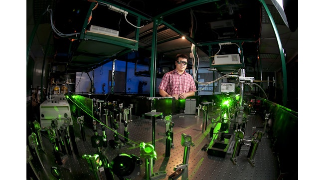 FIGURE 1. Hui Zhao in the University of Kansas Ultrafast Laser Lab with his team’s setup.