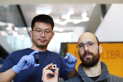 FIGURE 2. Yongje Wang (left) and Julian Schreier (right) hold samples of nontoxic quantum dots and a photodetector their team fabricated.