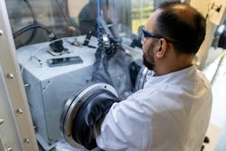 A scientist preparing a quantum-dot photodiode device for electrical measurement in a nitrogen-filled glove box.