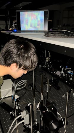 Otoya Shigematsu in the lab with the optical setup used for this work.