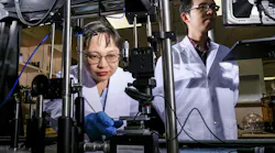 NTU Singapore research associate Liliana Tjahjana (left) loading a sample made of perovskites and gold onto a visible light detector, with Nanyang assistant professor Liang Jie Wong, also from the University, monitoring the setup.