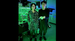 Jelena Vučković and Joshua Yang in the lab—he’s holding the laser and block of titanium-sapphire for scale.