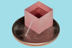 The group’s new laser leans against a block of titanium-sapphire, and both are shown atop a quarter for scale. The group’s new laser leans against a block of titanium-sapphire, and both are shown atop a quarter for scale.