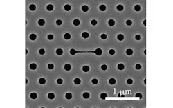 This image shows a top view of a photonic-crystal nanolaser biosensor, in which the center narrow slot (horizontal line) is the main part of the sensor. The size variation of the holes is intentional; the hole sizes are all optimized so that the laser's emission is effectively extracted to the top.