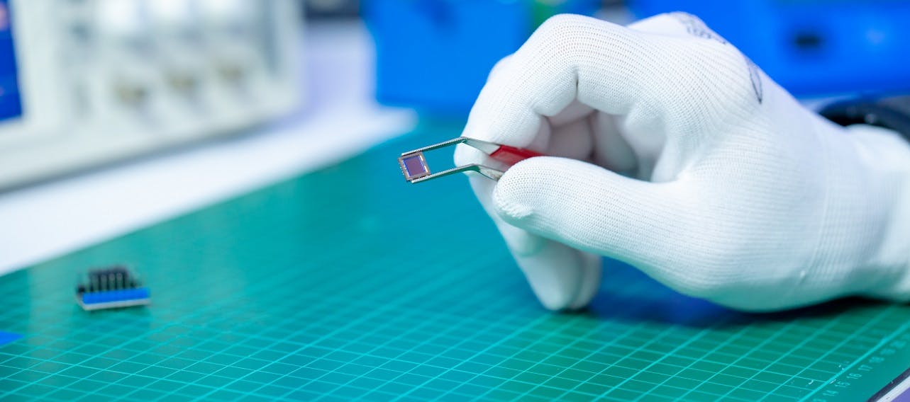 Image of gloved hand holding chip