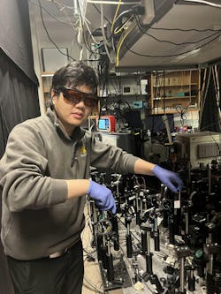 Lingxiao Zhou, a physics Ph.D. student, in the lab with the team’s setup. Lingxiao Zhou, a physics Ph.D. student, in the lab with the team’s setup.