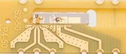 FIGURE 3. Using standard electronics-type assembly, a PLC-based diplexer chip can be mounted on a printed-circuit board. Impedance-matched traces that interface to the chip greatly improve radio-frequency performance compared to alternative technologies. FIGURE 3. Using standard electronics-type assembly, a PLC-based diplexer chip can be mounted on a printed-circuit board. Impedance-matched traces that interface to the chip greatly improve radio-frequency performance compared to alternative technologies.
