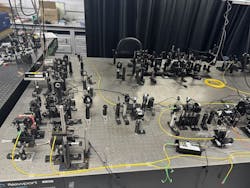 The team’s optical setup for constructing and characterizing metasurface quantum holograms. The team’s optical setup for constructing and characterizing metasurface quantum holograms.